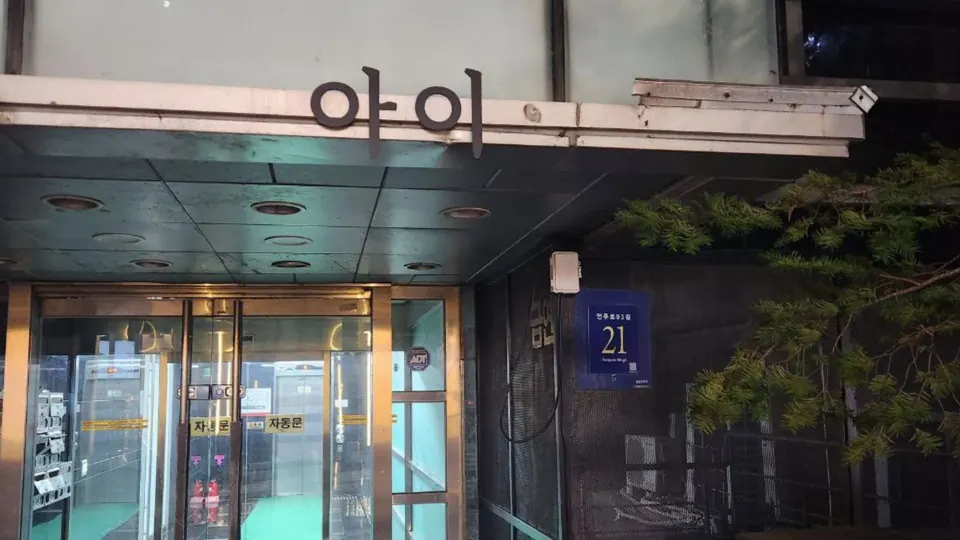 건물명과 도로명 표지가 보이는 유리 출입구